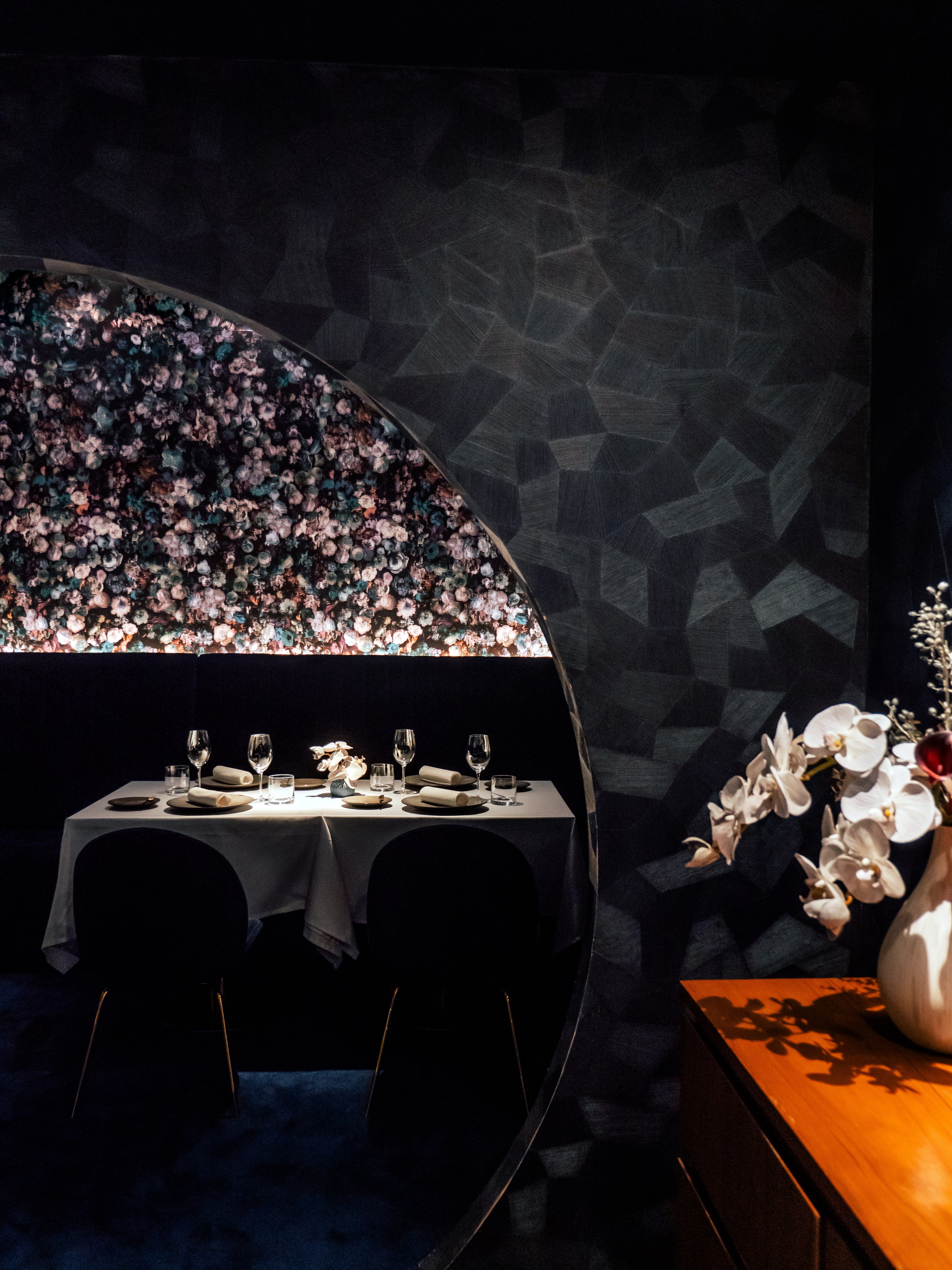 The dining room at Mia — arch, florals, warm light