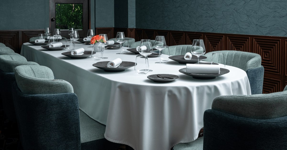 The private dining room at Mia, table dressed, teal velvet armchairs